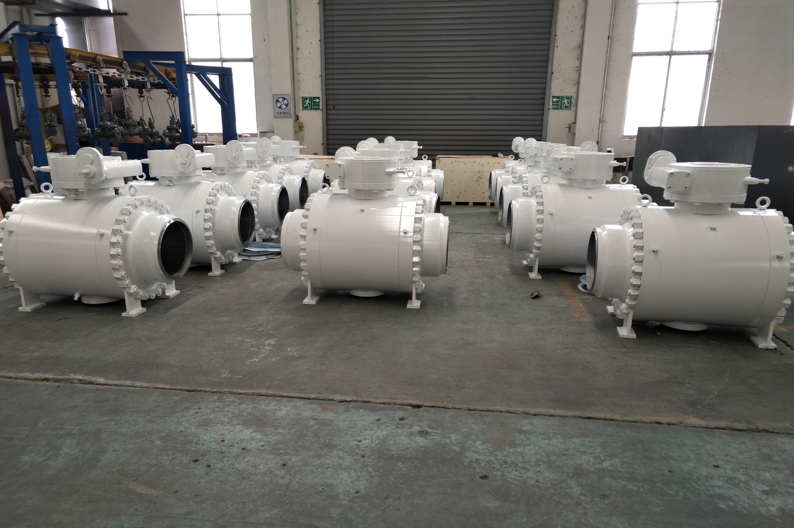 Three rows of white coloured ball valves arranged at a workshop by an industrial valve manufacturer in india